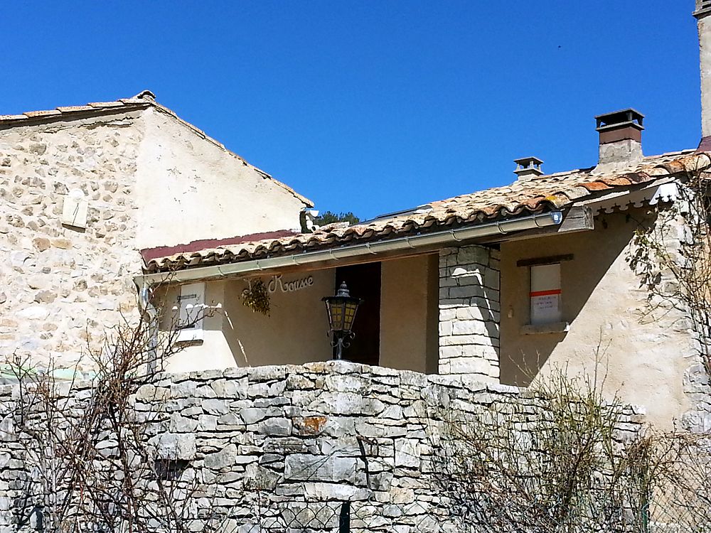 Ferme en pierre sous un ciel dégagé, gouttière et descente le long du toit